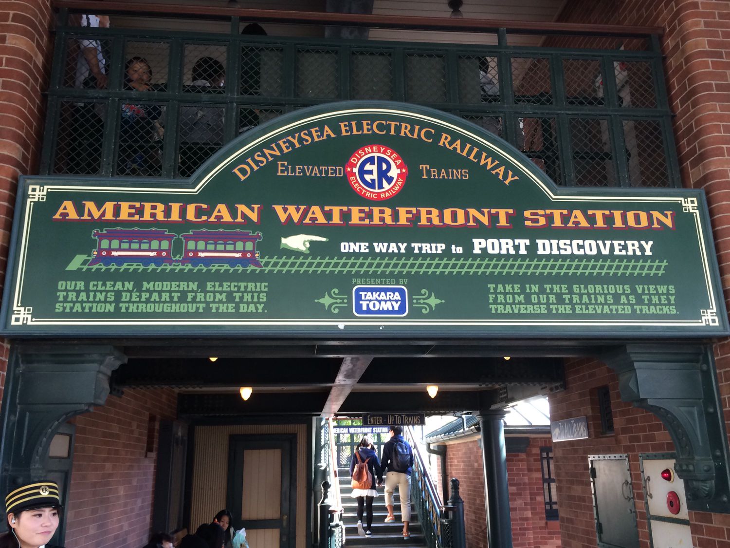 A large sign with the station name and a brief description of the train line hanging over the entrance of American Waterfront Station in Tokyo DisneySea in Urayasu, Japan.